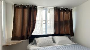 a bedroom with a bed and a window with curtains at The Dreamcatcher or Samui sunset Hostel in Nathon