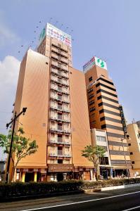 two tall buildings in a city with a street at Okayama Universal Hotel Annex in Okayama