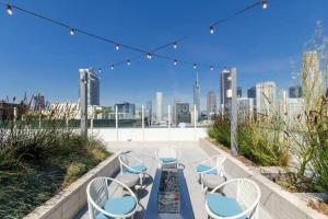 ロサンゼルスにあるStylish 3Bed HighRise with Pool, Spa, Rooftop Deckの市街の景色を望むパティオ(椅子、テーブル付)