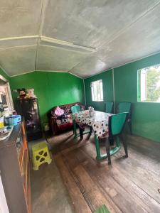 a green room with a table and chairs and a couch at DUMZAN Homestay and Farm in Takdāh