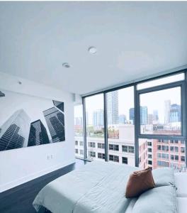 ein Schlafzimmer mit einem großen Bett und einem großen Fenster in der Unterkunft Stylish 3Bed HighRise with Pool, Spa, Rooftop Deck in Los Angeles