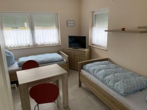 um quarto com duas camas e uma mesa e uma televisão em Villa Evi Modern retreat em Lubmin