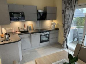 eine Küche mit Küchengeräten aus Edelstahl und einem Fenster in der Unterkunft Villa Evi Modern retreat in Lubmin