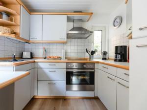 a kitchen with white cabinets and a stove at Panorama Modern retreat in Eslohe