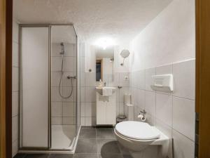 a white bathroom with a toilet and a shower at Panorama Modern retreat in Eslohe +29 photos