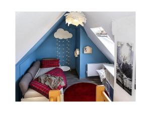 Habitación infantil con cama en habitación azul en Dandelion Modern retreat, en Leezdorf