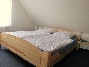 een houten bed in een slaapkamer met een raam bij Klabautermann Comfortable holiday residence in Hooksiel