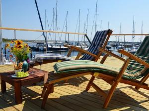 two chairs and a table on the deck of a boat at Premium houseboat on the lake in Heiligenhafen