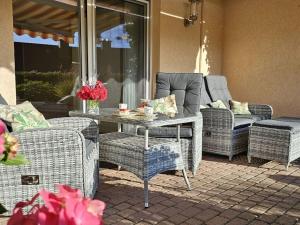 patio z wiklinowymi krzesłami oraz stołem i krzesłami w obiekcie Fasse Comfortable holiday residence w mieście Delliehausen