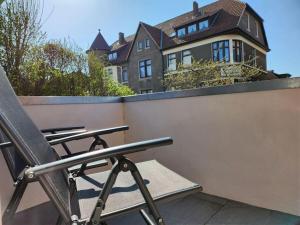 a chair sitting on a balcony in front of a house at Sound of the sea Modern retreat in Wangerooge