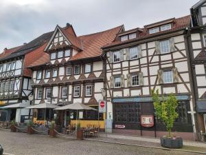un gran edificio con mesas y sombrillas en una calle en Fasse Comfortable holiday residence en Delliehausen