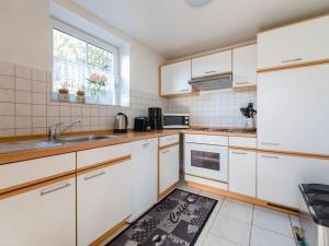 eine Küche mit weißen Schränken und einem Küchenteppich auf dem Boden in der Unterkunft Salweyblick Modern retreat in Niedersalwey