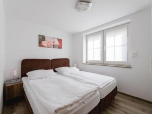 Schlafzimmer mit einem Bett mit weißer Bettwäsche und einem Fenster in der Unterkunft Salweyblick Modern retreat in Niedersalwey