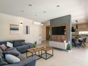 ein Wohnzimmer mit einem blauen Sofa und einem TV in der Unterkunft Villa Bella Vita in Barban