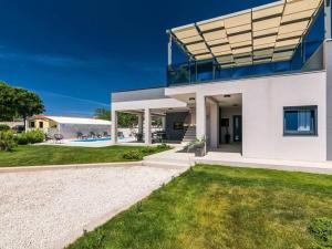 ein weißes Haus mit Pool im Hinterhof in der Unterkunft Villa Bella Vita in Barban