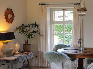 een eetkamer met een tafel en een raam bij Rose Cottage Comfortable holiday residence in Petershagen
