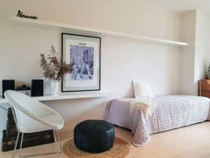een slaapkamer met een bed, een stoel en een plank bij Rose Cottage Comfortable holiday residence in Petershagen