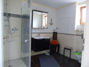 uma casa de banho com uma cabina de duche em vidro e um lavatório. em Csilla Comfortable holiday residence em Unterweid