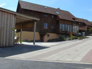 um grande edifício de madeira com um pavilhão ao lado de uma rua em Csilla Comfortable holiday residence em Unterweid