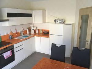 uma cozinha com armários brancos e electrodomésticos pretos em Strandhus Modern retreat em Lubmin