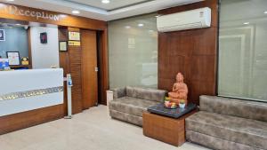 a lobby with a couch and a statue on a table at Hotel Alankar Palace in Bhopal