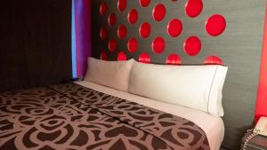 Schlafzimmer mit einem Bett mit einem roten und schwarzen Kopfteil in der Unterkunft Smae in Mexiko-Stadt