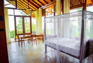 Schlafzimmer mit einem Bett, einem Tisch und Stühlen in der Unterkunft Tea Forest Eco Lodge in Kandy