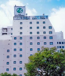 un edificio con un reloj encima en Okayama Ekimae Universal Hotel, en Okayama