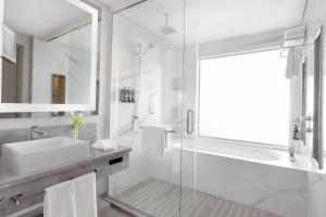 a white bathroom with a sink and a shower at Crowne Plaza Hotel Riyadh Minhal, an IHG Hotel in Riyadh