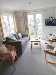 a living room with a couch and a table at 1 Bell Lodge, Thorpeness in Thorpeness