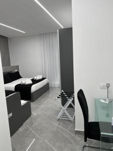 a bedroom with a bed and a table and a chair at White Elegance Luxury B&B Caserta in Caserta