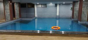 a swimming pool with a orange raft in the water at hotel badri palace in Jodhpur