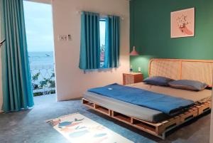 1 dormitorio con 1 cama con sábanas azules y paredes verdes en Kaktus home & kafe en Tuy Hoa