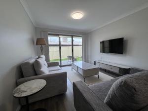 a living room with a couch and a tv at French Corner Apartments in Dubbo