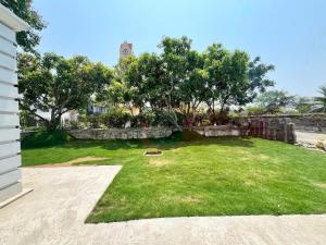 a yard with grass and trees and a building at Raichak Bungalow Booking - Mallika C2 in Raichak