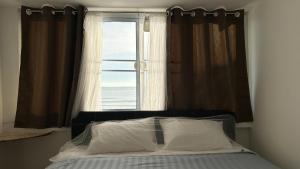 1 cama en un dormitorio con ventana en The Dreamcatcher or Samui sunset Hostel, en Nathon