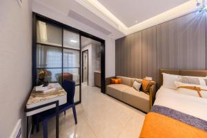 a bedroom with a bed and a desk and a couch at Xi Ke Executive Apartment - Shenzhen Futian Exhibition Center in Shenzhen