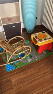 ein Kinderspielzeug auf einem Boden mit einem Stuhl und einem Tisch in der Unterkunft Casetta zia Tetti in Lecce