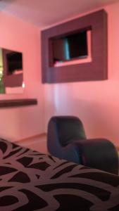 ein rosafarbenes Zimmer mit einem Stuhl und einem TV in der Unterkunft Smae in Mexiko-Stadt
