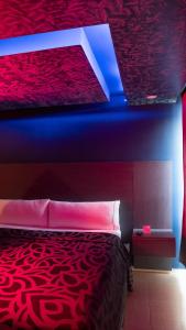 ein Schlafzimmer mit einem roten Bett mit blauer Decke in der Unterkunft Smae in Mexiko-Stadt