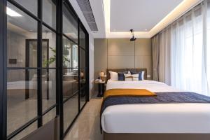 a bedroom with a large bed and a bathroom at Xi Ke Executive Apartment - Shenzhen Futian Exhibition Center in Shenzhen