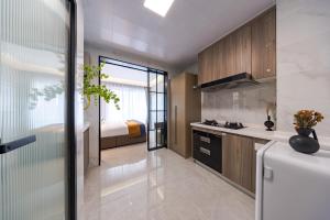 a kitchen with a white refrigerator and a bedroom at Xi Ke Executive Apartment - Shenzhen Futian Exhibition Center in Shenzhen