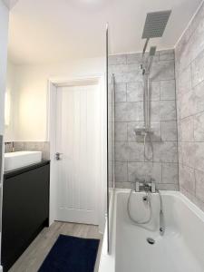 een badkamer met een bad en een wastafel bij Campbells Crib in Kent