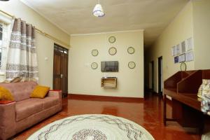 uma sala de estar com um sofá e uma televisão em Janibichi Adventures hostel em Moshi
