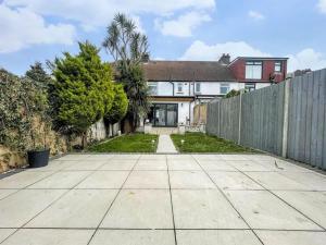 an empty driveway in front of a fence at Beautiful Bright Three Bedroom House in Brighton and Hove with free parking in Portslade