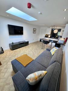 a living room with a couch and a flat screen tv at Sheraton Apartments in Fort William
