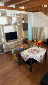 ein Wohnzimmer mit einem Tisch und einem TV in der Unterkunft Casetta zia Tetti in Lecce
