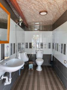 綏和的住宿－Kaktus home & kafe，浴室配有盥洗盆、卫生间和浴缸。