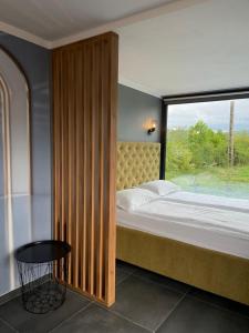 a bedroom with a bed with a large window at KUBIQ TRANSALPINA in Petreşti