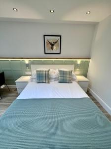 a bedroom with a large white bed with two pillows at 9 Sheraton Apartments in Fort William